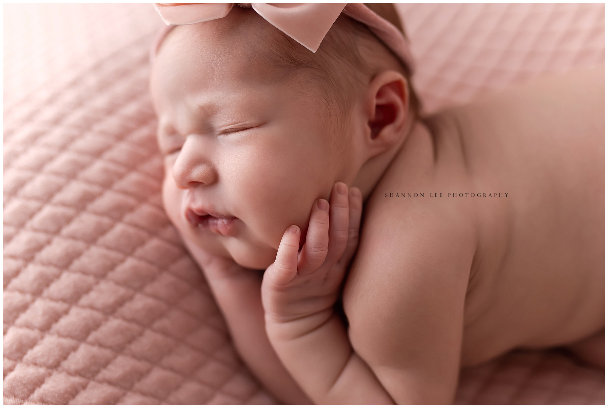 Newborn baby girl close up with pink bow